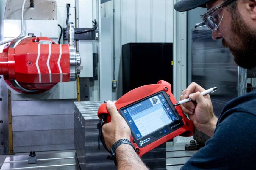 Technician using a Fixturlaser alignment system to analyze machine vibrations and record diagnostic data.